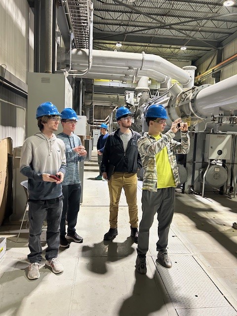 4 students standing in front of a pipe.