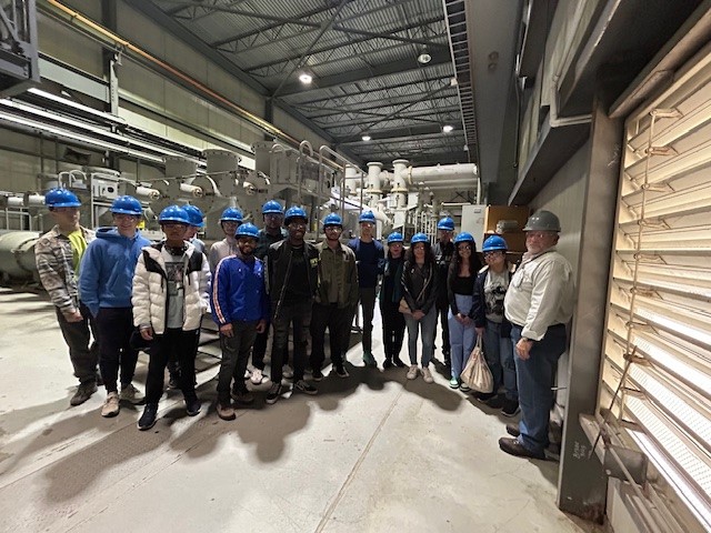 Stem club students with blue helmets in the inside of the plant.